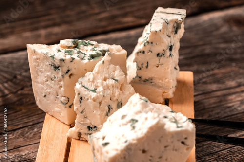 Tasty blue cheese on a wooden background. Dorblu cheese pieces, Danish blue cheese