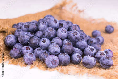 A bunch of blueberries on a napkin on a white background.
Close-up.