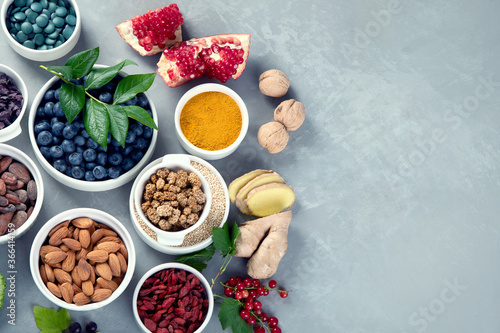 Various superfoods on grey background.