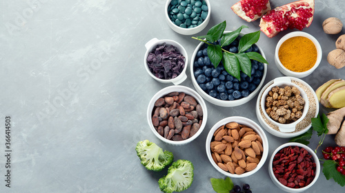 Various superfoods on grey background.