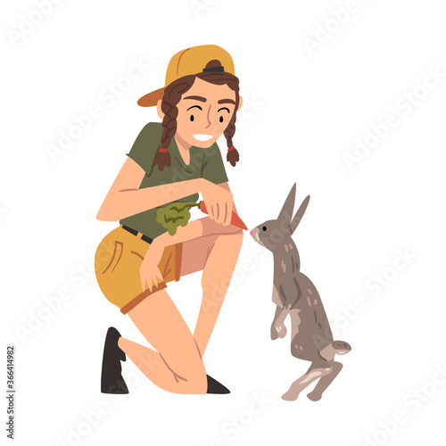 Female Zoo Worker Feeding Rabbit with Fresh Carrot, Veterinarian or Professional Zookeeper Character Caring of Wild Animals in Zoo Cartoon Vector Illustration