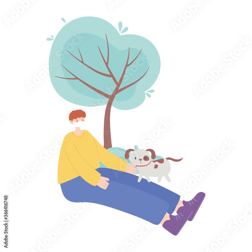 people with medical face mask, boy sitting with dog in the park, city activity during coronavirus