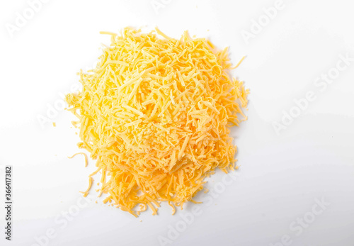 Grated hard cheese on a white plate. Russian cheese, Dutch, parmesan heap grated on a white plate in a close-up top and top view