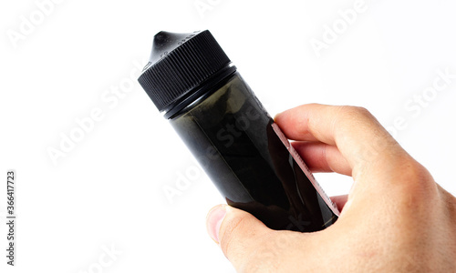 Black bottle, vial, bottle capacity 120 mm on white background in close-up, in a man's hand. Bottle with cap for children