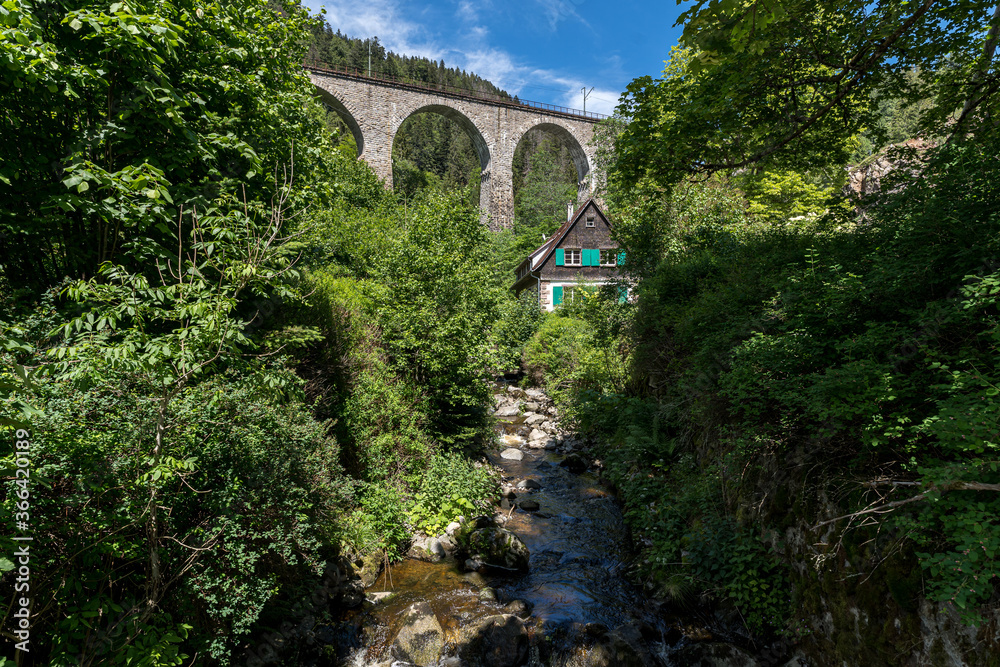 Spectacular view of an old house in front of the old railway bridge at the Ravenna gorge viaduct in Breitnau, Germany