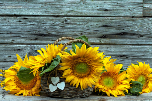 Sonnenblumen mit Blumenstrauss vor Holz