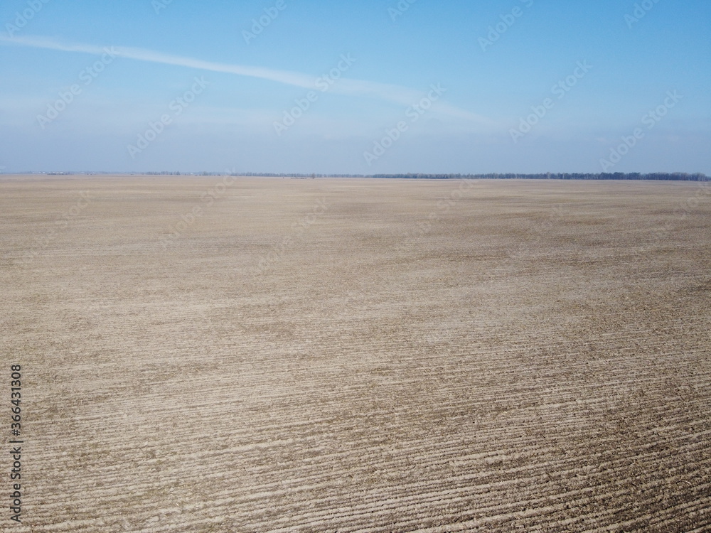 Naklejka premium Agricultural fields on a sunny spring day, aerial view. Landscape. Blue sky over the fields.