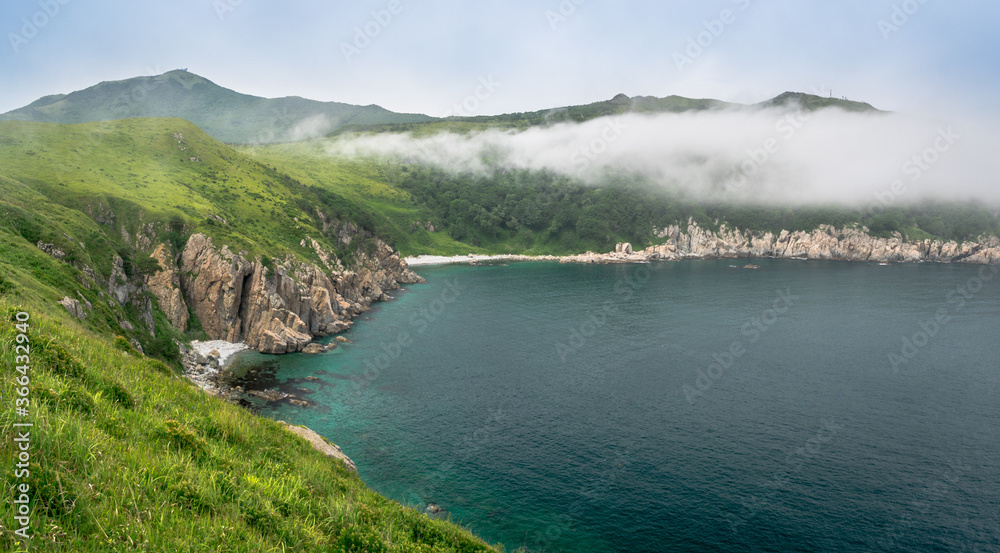 Sea bay with high cliffs covered with green vegetation Sea bay with high cliffs covered with green vegetation