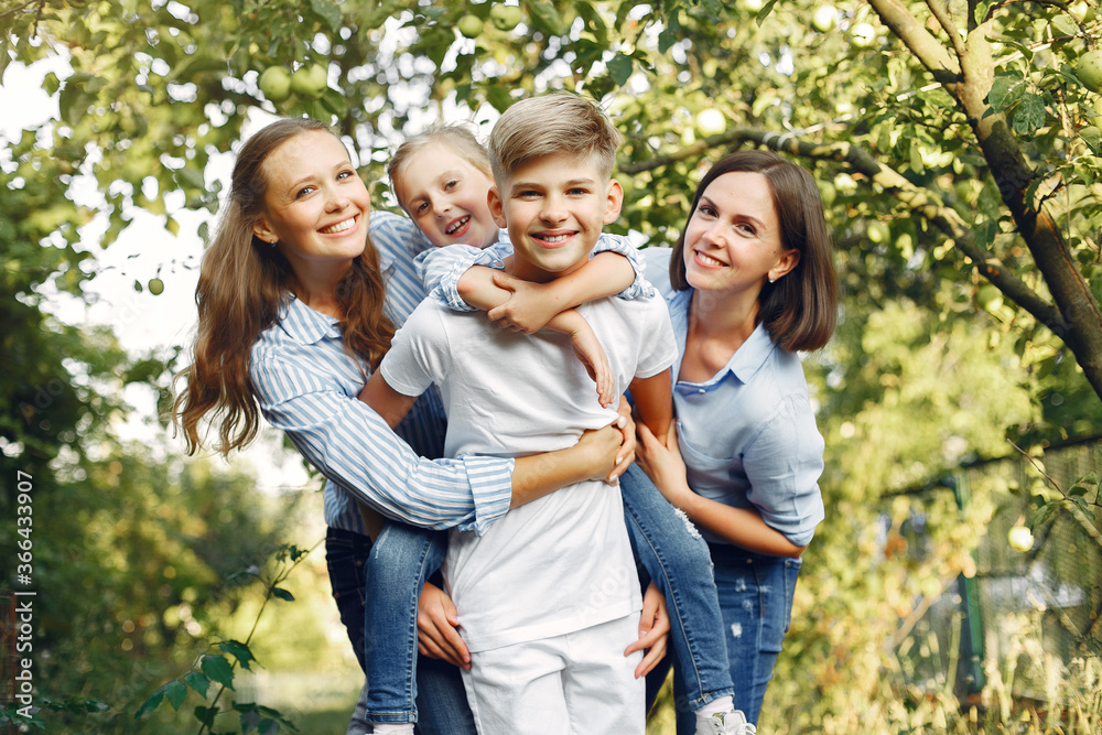 Obraz premium Family in a park. Children near apple tree. Woman in a blue shirt
