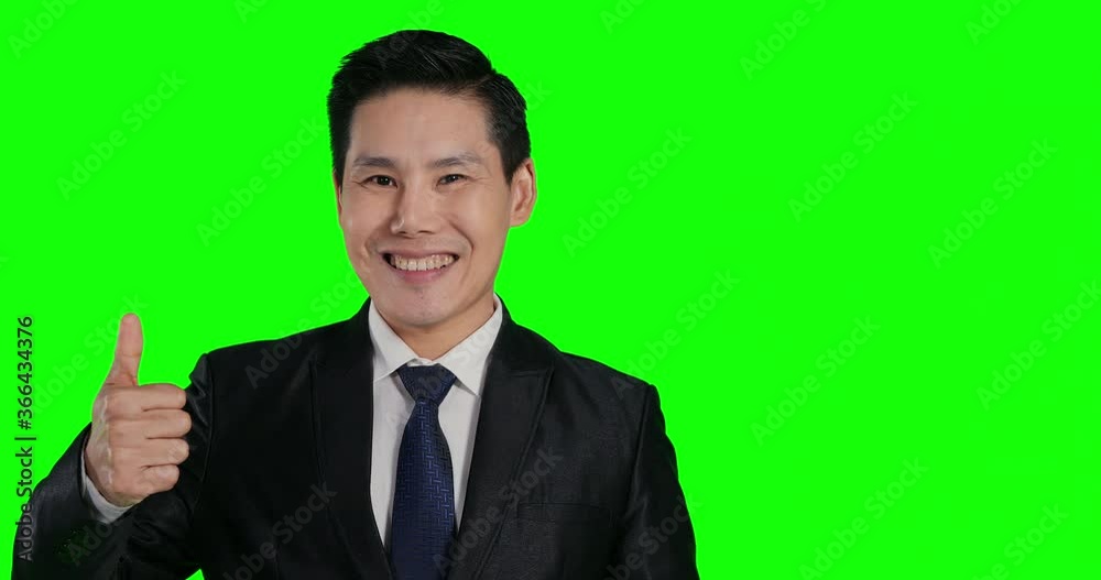 Portrait of businessman looking to camera with attractive smile. He showing ok sing to camera at green screen background. Portrait of businessman looking to camera with attractive smile. He showing ok sing to camera at green screen background.