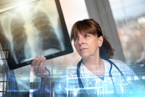 Female doctor examining x-ray report; multiple exposure