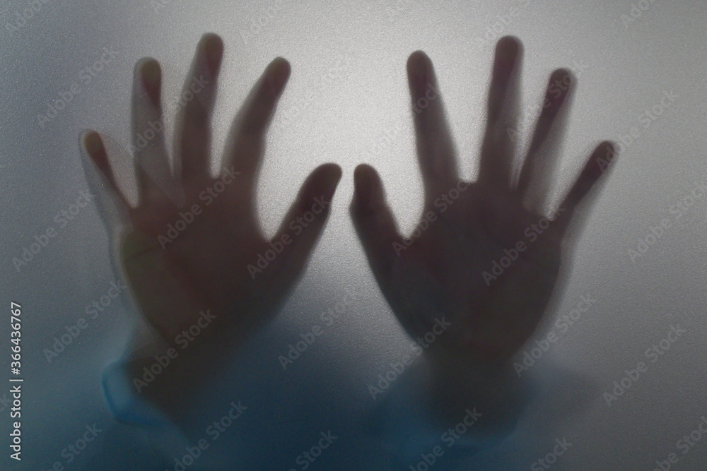 Woman hands behind glass. Hands silhouette figure horror concept.