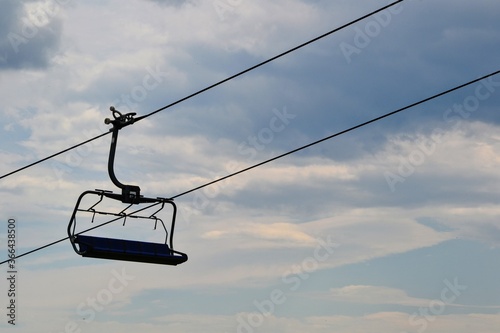 Mountain chairlift. 4-seater chairlift. The ski lift going tothe station. Close up of an empty four person chair lift hanging at a ski lift wires