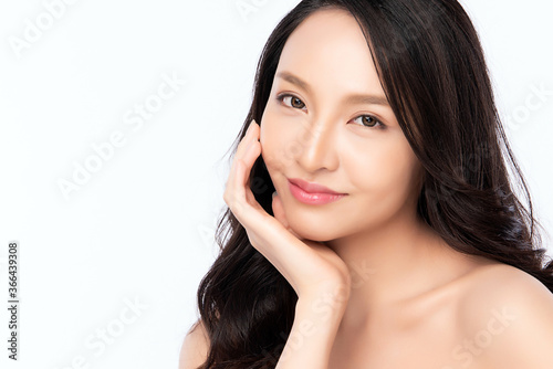 close up Beauty face. Smiling asian woman touching healthy skin portrait. Beautiful happy girl model with fresh glowing hydrated facial skin and natural makeup on white background,