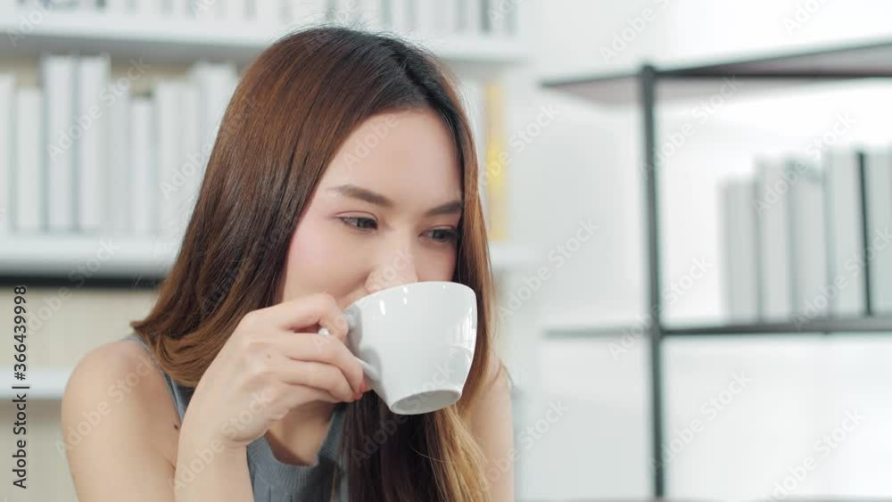 Asian woman drinking latte coffee enjoying fresh new day feeling rested and drinking coffee at home. Happy with coffee.
Asian woman drinking latte coffee enjoying fresh new day feeling rested and drinking coffee at home. Happy with coffee.