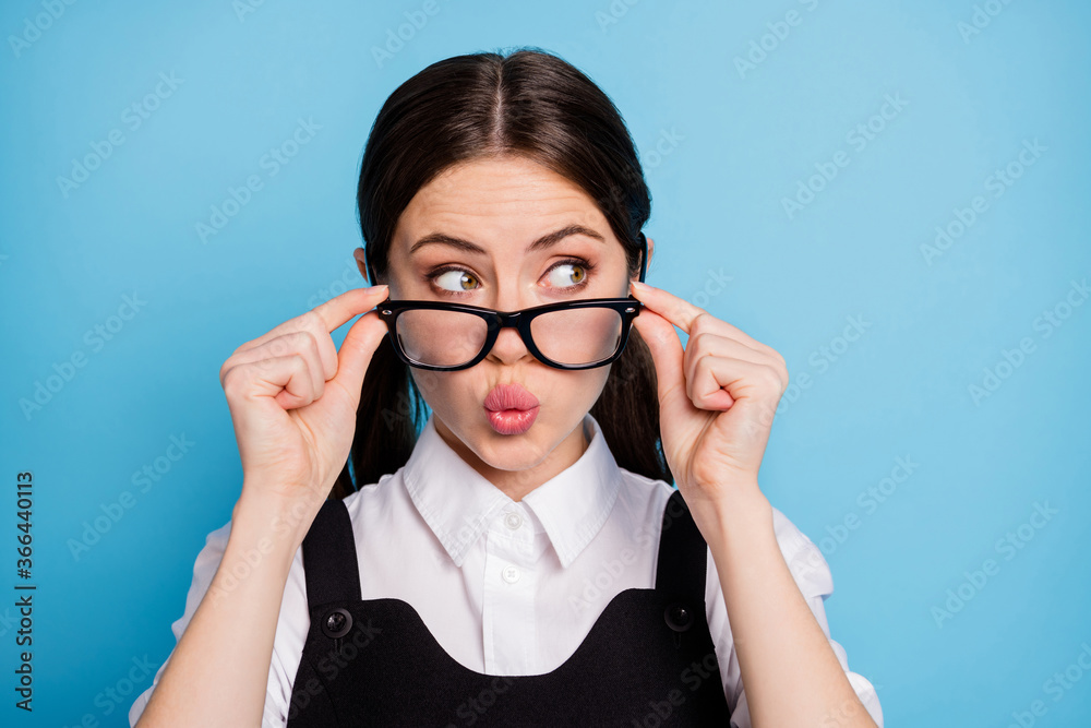 Close-up portrait of her she nice attractive pretty lovely brainy schoolgirl nerd geek touching specs pout lips looking aside spying isolated on bright vivid shine vibrant blue color background Close-up portrait of her she nice attractive pretty lovely brainy schoolgirl nerd geek touching specs pout lips looking aside spying isolated on bright vivid shine vibrant blue color background