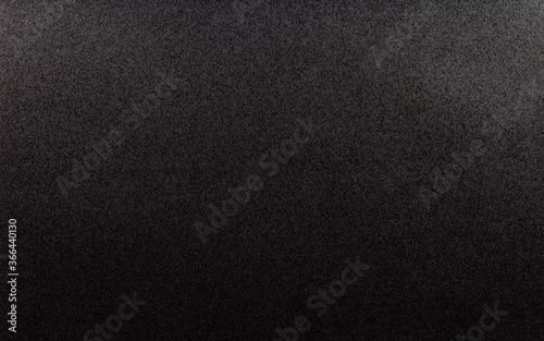 Closeup of black, rough background lit with dim light.