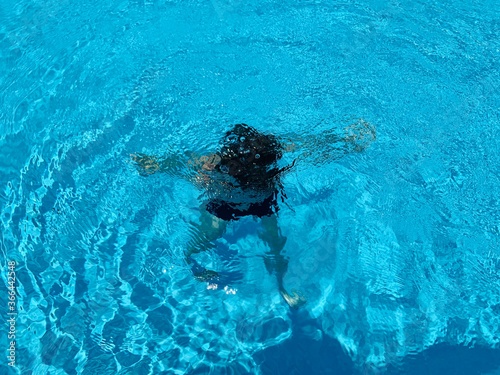 Boy swimming underwater in swimming pool