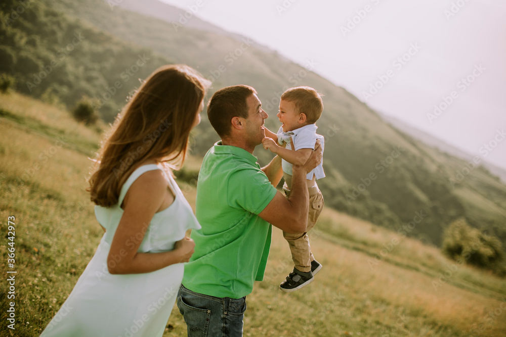 Fototapeta premium Young family having fun outdoors in the field