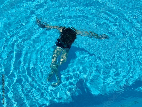 Boy swimming underwater in swimming pool