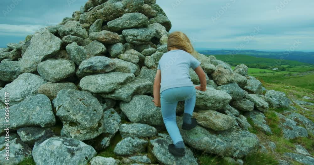 Preschooler climbing rocks on the moor in summer Preschooler climbing rocks on the moor in summer