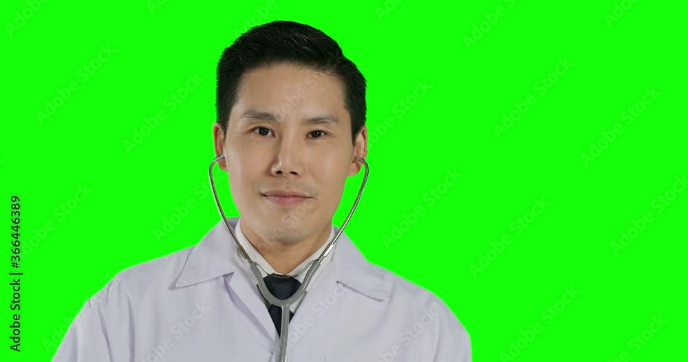 Portrait of male doctor posing to camera with smile at green screen background. Portrait of male doctor posing to camera with smile at green screen background.