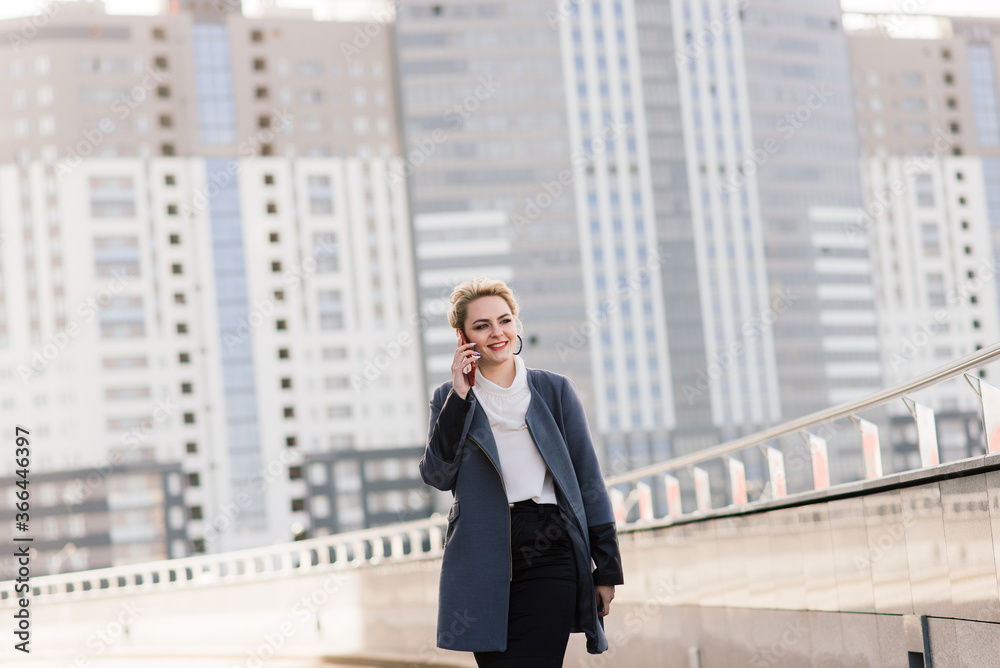 Lawyer businesswoman professional walking outdoors talking on cell smart phone drinking coffee from paper cup. Lawyer businesswoman professional walking outdoors talking on cell smart phone drinking coffee from paper cup.