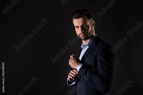 Profile side view portrait of his he nice attractive content rich wealthy fashionable trendy guy corporate partner agent broker fastening button isolated over dark black color background