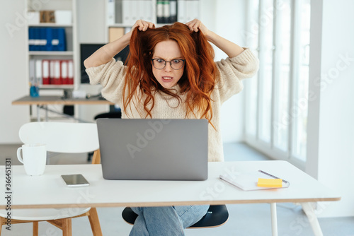 Frustrated businesswoman tearing at her long hair