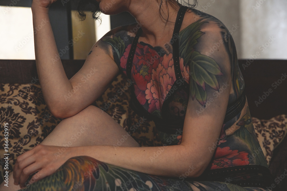 Fototapeta premium tatoo girl on the sofa in home