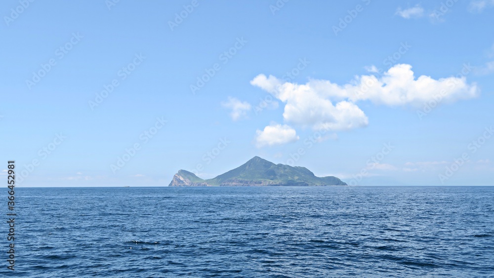 An outlying island in Taiwan in a clear sunny day with blue sea. An island look like a turtle.