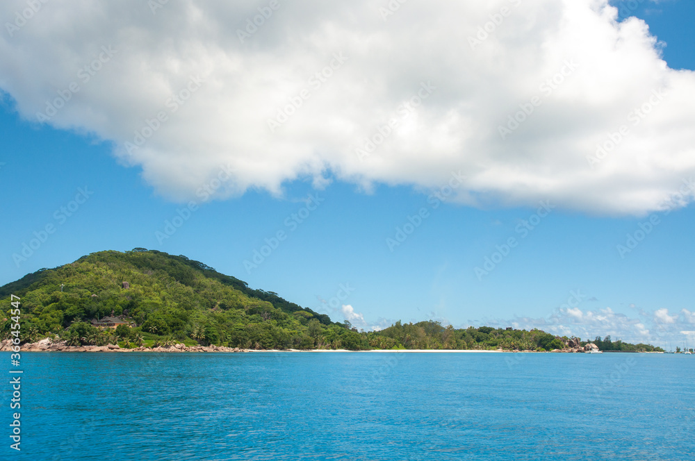 Scenic view of La Digue Island with white beach and blue sky. Seychelles