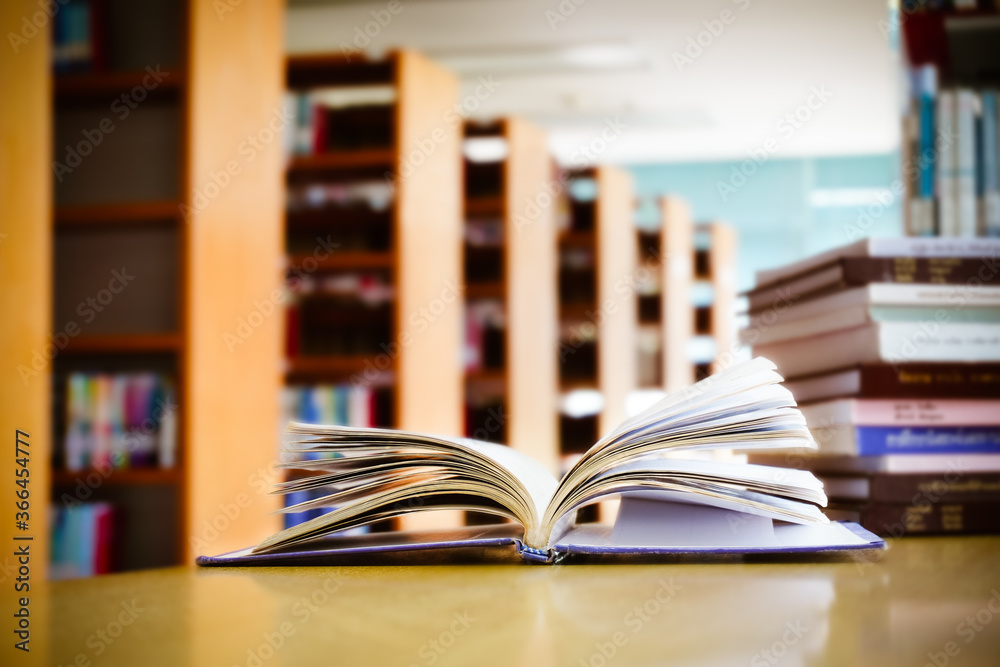 Opening book or textbook with bookshelf in the library.Education concept. Opening book or textbook with bookshelf in the library.Education concept.