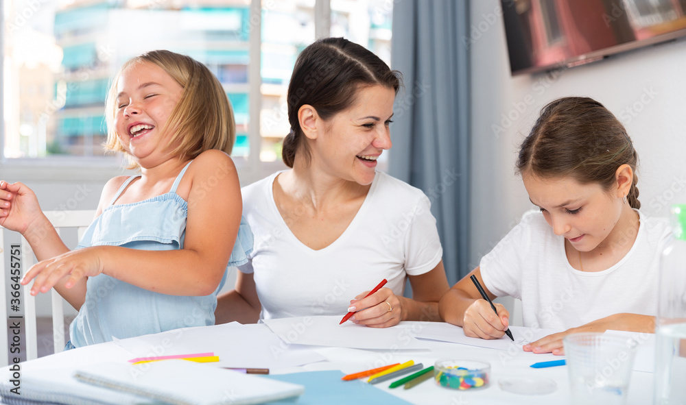 Obraz premium Mother and two children together with wax crayons in home