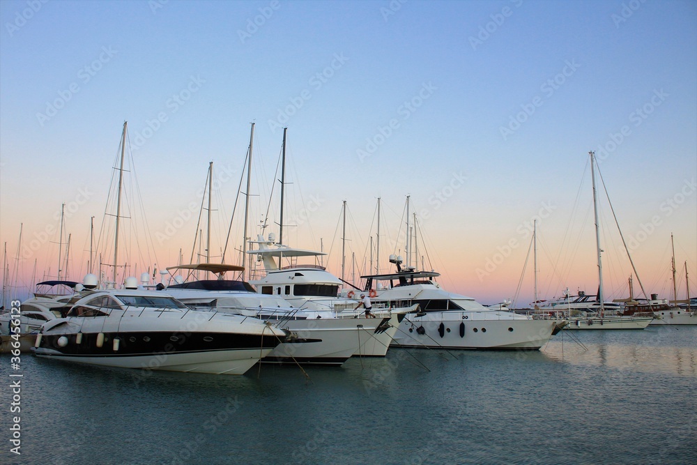 yatchs and other boats moored at the harbor of Ostia (Rome) in the fascinating atmosphere of the summer sunset
