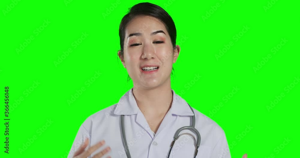 Portrait of female doctor talking to camera at green screen background. She using conference call to talking with team. Technology, Healthcare and Medical concept. Portrait of female doctor talking to camera at green screen background. She using conference call to talking with team. Technology, Healthcare and Medical concept.