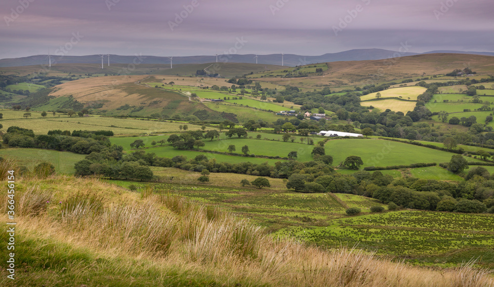 Wind turbines and a green fields on the Betws mountain in South Wales, UK