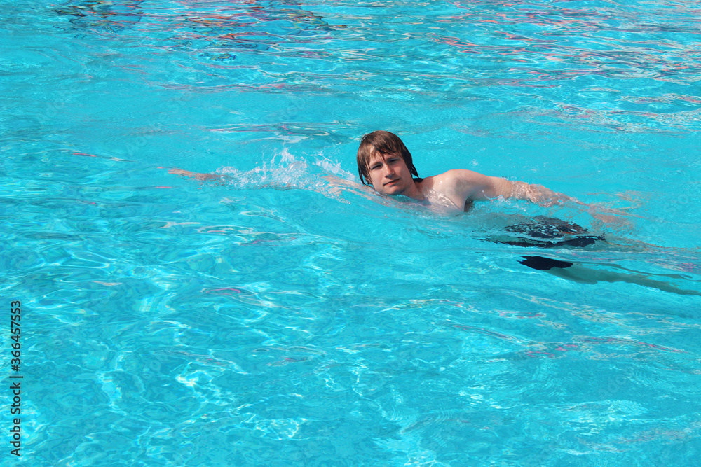 Man swim in blue swimming pool. Recreation.