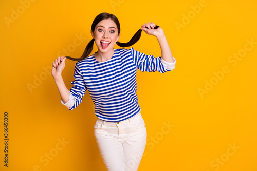 Portrait of her she nice attractive pretty lovely cheerful cheery playful comic brown-haired schoolgirl having fun showing tongue out isolated on bright vivid shine vibrant yellow color background © deagreez