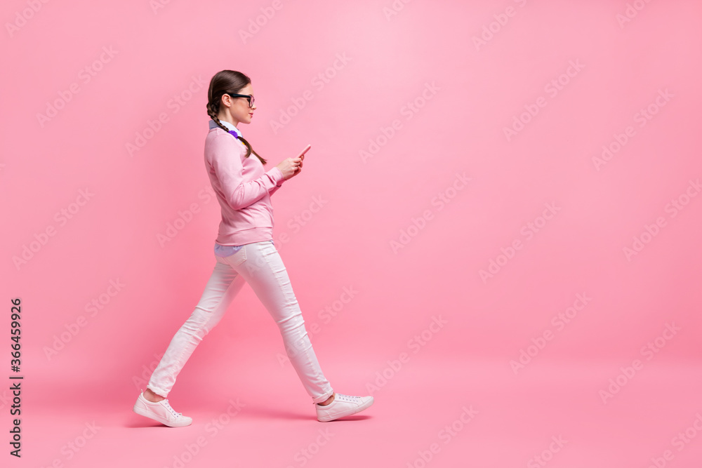 Full length body size profile side view of her she attractive lovely pretty focused addicted girl nerd strolling browsing comment feedback media multimedia isolated over pink pastel color background