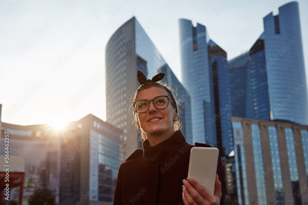 Woman using cellphone in urban surroundings with skyscrapers. Woman using cellphone in urban surroundings with skyscrapers.