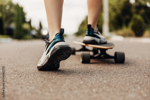 Close-up of female legs wearing sneakers on skateboard.