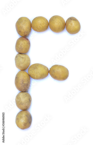 Letter F of the English alphabet from potatoes. A letter made of fruit on a white background.