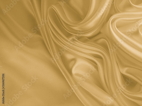 Beautiful smooth elegant wavy golden yellow satin silk. Luxury cloth fabric texture, abstract background design. Copy space.  © Sindija