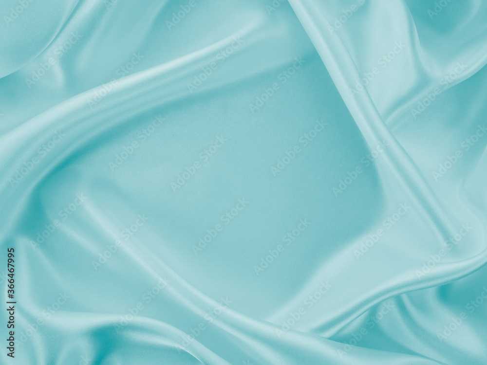 Obraz premium Beautiful elegant wavy turquoise silk or satin luxury cloth fabric texture, abstract background design.