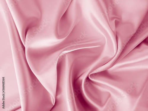 Beautiful elegant wavy pale pink satin silk luxury cloth fabric texture, abstract background design. Copy space