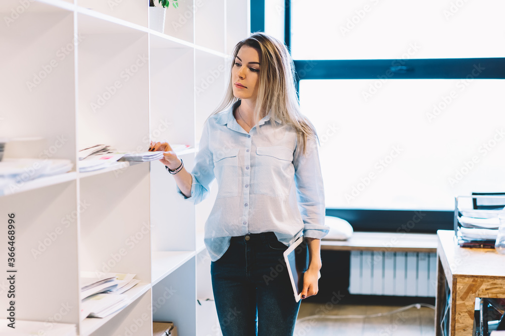 Office worker taking documents from shelf Office worker taking documents from shelf