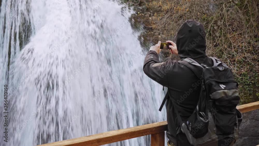 Hiker standing by waterfall outdoors in winter Cinemagraph Hiker standing by waterfall outdoors in winter Cinemagraph