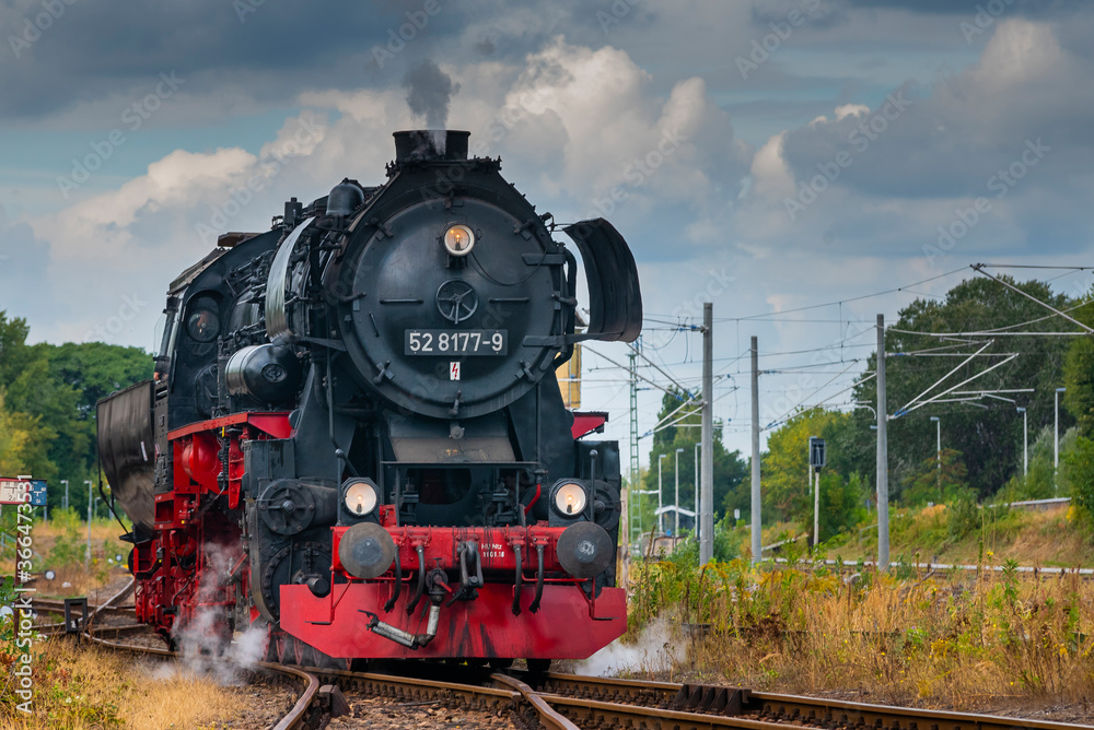 Naklejka premium Steam Locomotive, german Steam Locomotive, Steam Locomotive and big Clouds in Background