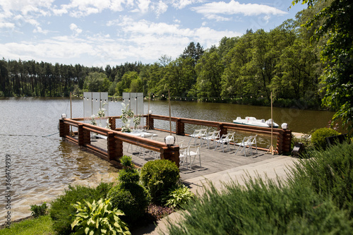 Beautiful wedding ceremony place on the lake with natural materials in white color
